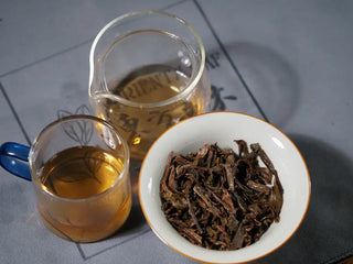 Tea liquor, fair cup, and gaiwan wet leaves of the Sticky Rice Aroma Raw Pu-erh Cake 2013 200g displayed together