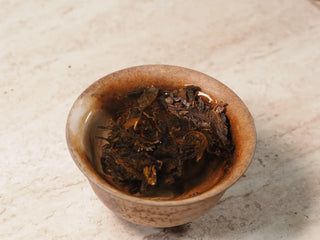 Steeping tea leaves of Value Classic 2008 Tribute Sheng Pu-erh Tea Cake – 357g Menghai (2019 Pressed) fully immersed in hot water inside gaiwan
