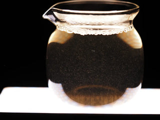 Bright tea liquor of 2023 Jinggu Silver Needle White Tea showing abundant silvery downy hairs under light