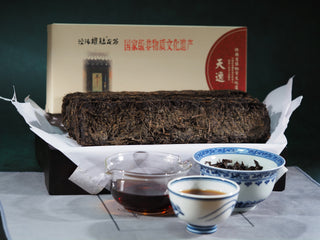Full product display of the 2015 Genshe Heritage Fu Brick Tea, including the packaging, dry brick, and brewed tea.
