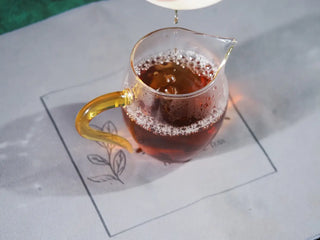 Rich, clear amber tea liquor of the On Taoism Fucha, brewed and presented in a glass server.