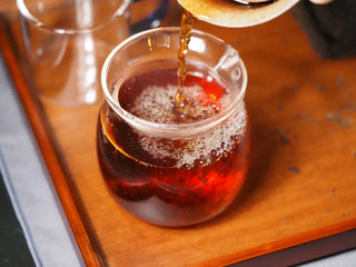 Rich, dark red liquor of YXT Jingyang Fu Tea Ximanzi 2018 Premium Shaanxi Dark Tea in a transparent glass.