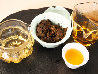 Complete gongfu setup for 2018 Fuding Shou Mei: two pitchers, white gaiwan and tasting cup of amber liquor on wooden tray.