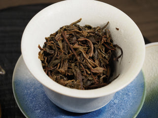A detailed view of the brewed wet leaves (infusion) of 2020 Dayi 7542 raw puerh showing active leaf veins.
