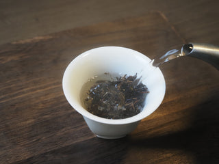 Brewing Mangfei Mountain raw Pu-erh tea by pouring hot water into a gaiwan