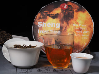 A traditional Chinese Gongfu tea session setup featuring clear golden Lao Man'e raw Puerh tea and artisanal teaware.