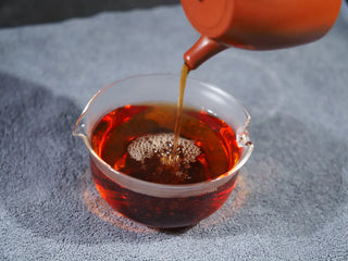 Pouring the brewed Fu Brick tea showing a clear and bright amber tea liquor.