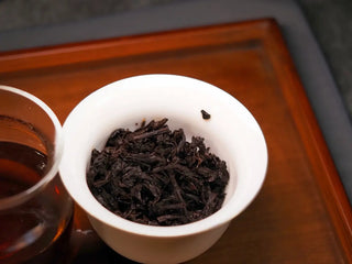 Infused leaf base of Qilin Hao Fengshan Gushu Ripe Pu-erh Tea Cake 2021, showing uniform dark reddish leaves
