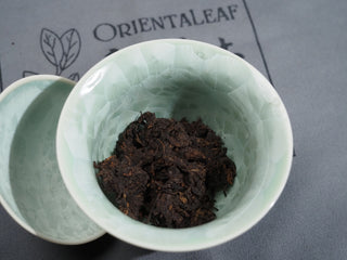 Wet tea leaves inside a white porcelain Gaiwan after rinsing the 2006 Dayi 7572 ripe Puerh