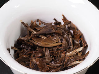 Close-up of the steeped leaves (ye di) of Yunnan Jinggu White Peony Tea Cake 357g in a gaiwan, showing tender first leaves and buds