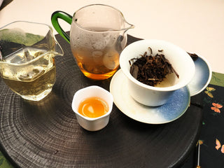 Complete gongfu setup for 2014 Fuding Shou Mei waffle cake: two pitchers, tasting cup, gaiwan and steeped leaves on wooden tray.