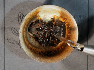 Top-down view of pouring hot water into gaiwan for rinsing Bulang Mountain Ancient Tree Ripe Pu-erh tea leaves