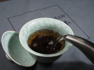 Pouring hot water from kettle into Gaiwan to brew 2006 Dayi 7572 ripe Puerh tea