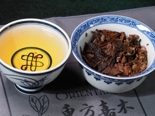 Gaiwan and tasting cup together showing brewed Yunnan High Mountain Wild Ancient Tree Shoumei White Tea (2019), tea liquor and leaf base visible