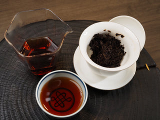 Complete Chinese Gongfu tea setup for 2021 Dayi 7572 ripe puerh, featuring a Gaiwan, glass pitcher, and tea cup.