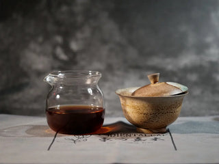 Gaiwan and glass gongdao cup with rich red tea liquor of Bulang Mountain Ancient Tree Ripe Pu-erh, front view