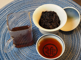 Complete Gongfu tea brewing spread showing gaiwan, fairness cup, and aged Shou Pu-erh tea liquor