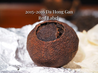 Close-up of an unwrapped whole Tengma Da Hong Gan citrus Pu-erh tea ball showing the dark aged peel.