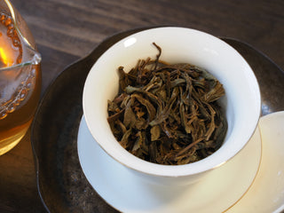 Expanded wet ancient tree sheng pu-erh tea leaves after brewing in gaiwan