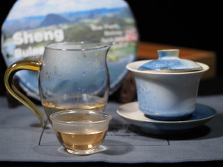 Traditional Gongfu tea session setup featuring clear golden Sheng Bulang Buds Puerh tea and porcelain teaware.