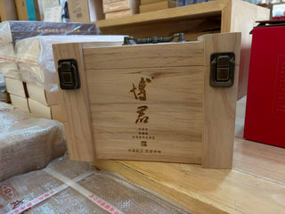5-Cake Wooden Box of Mengku Rongshi Bojun Ripe Pu-erh 7.0 with engraved branding, dark wood and brass hardware.