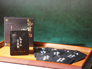 Close-up of On Taoism Golden Flower White Tea mini-cakes and packaging, ready for tasting.