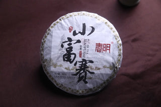 Close-up detail of the 2018 Xiao Hu Sai Sheng Pu-erh Tea wrapper, highlighting the brand and year.