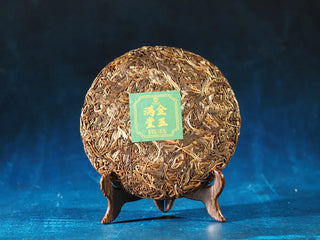 Front view of 2023 Menghai First-Flush Golden Abundance Raw Puerh Tea Cake (357g) without packaging, displaying tight, elegant tea cake and plump buds.