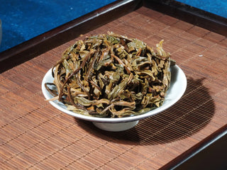 Close-up of the tea leaves at the lid of gaiwan with 2023 Menghai First-Flush Golden Abundance Raw Puerh Tea (357g), showing expanded leaf tips.