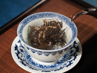 Hot water being poured into a gaiwan with 2023 Menghai First-Flush Golden Abundance Raw Puerh Tea (357g), illustrating first infusion process.