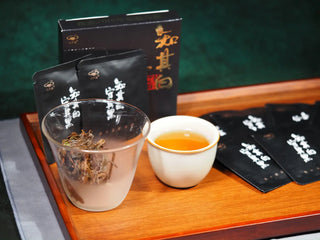 On Taoism Golden Flower White Tea Single Serve Packs tasting set presentation with hot tea liquor and packaging.