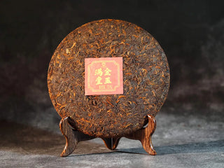Golden Treasure Ripe Puerh Tea Cake – Menghai Origin, front view of the unwrapped tea cake showing dark brown leaves with densely packed golden tips.