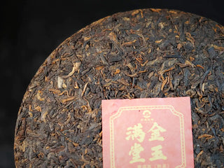 Golden Treasure Ripe Puerh Tea Cake – Menghai Origin, close-up detail of the tea cake’s surface, highlighting dark brown leaves with dense golden tips.