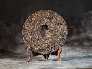 Golden Treasure Ripe Puerh Tea Cake – Menghai Origin, front view of the back side of the tea cake, showing dark brown leaves with scattered golden tips.