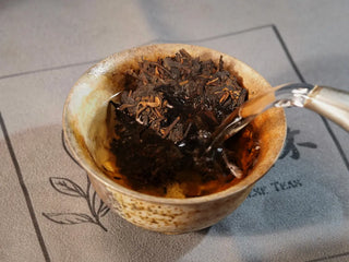 Golden Treasure Ripe Puerh Tea Cake – Menghai Origin, first infusion with hot water poured into the gaiwan containing the tea leaves.