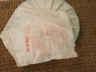 Close-up of the paper wrapper label on Jing Chang Hao Deep Velvet 2020 ripe Pu-erh cake showing production details and date