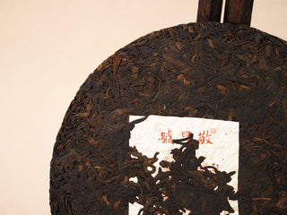 Close-up of Jing Chang Hao Deep Velvet 2020 ripe Pu-erh cake surface showing dense dark-brown fermented tea leaves