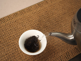Rinsing Jing Chang Hao Deep Velvet 2020 ripe Pu-erh leaves in a white gaiwan with boiling water before the first steeping
