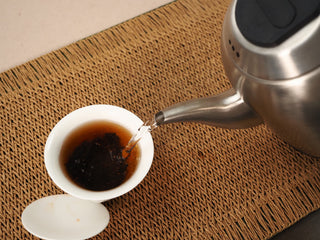 Boiling water poured over Jing Chang Hao Deep Velvet 2020 ripe Pu-erh in a gaiwan, releasing a clear red-brown liquor