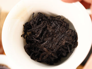 Wet leaves of Jing Chang Hao Deep Velvet 2020 ripe Pu-erh in a gaiwan after steeping, glossy dark-brown and fully unfurled