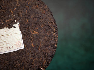 Close-up of the front surface of the bare tea cake, revealing aged Pu-erh leaf texture