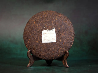 Full front view of the bare Ancient Grove 2018 Lincang old-tree ripe Pu-erh tea cake