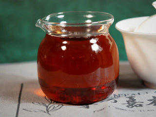 Chang'an Golden Flower Fu Brick Tea Mini Cake – 60g close-up of amber-red tea liquor in glass fair cup