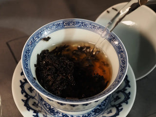 Close-up of boiling water poured over Classic 1973 Large 400g Ripe Pu-erh Tea Cake Menghai leaves in a gaiwan for 2nd brew