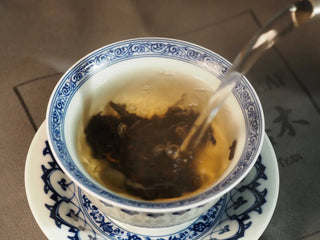 Close-up of boiling water poured over Classic 1973 Large 400g Ripe Pu-erh Tea Cake Menghai leaves in a gaiwan
