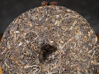 Close-up of the back of Hidden Mountain Raw Pu-erh Tea Cake (357g), showing leaf detail, high-mountain Yunnan origin, and small-batch quality.