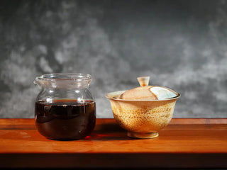 Mixiang 2017 Ripe Pu-erh Tea – MengHai Mid-Aged Golden Tip Pu-erh front view of a gaiwan and a glass fairness cup placed together, showcasing the tea and brewing setup