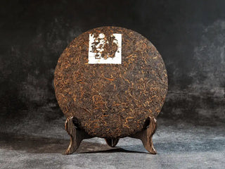 Mixiang 2017 Ripe Pu-erh Tea – MengHai Mid-Aged Golden Tip Pu-erh front view of the unpackaged tea cake, showing golden buds and dark brown leaves on the surface