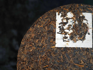 Mixiang 2017 Ripe Pu-erh Tea – MengHai Mid-Aged Golden Tip Pu-erh close-up of the front surface of the tea cake, highlighting the texture and golden buds