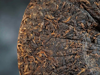 Mixiang 2017 Ripe Pu-erh Tea – MengHai Mid-Aged Golden Tip Pu-erh close-up of the back surface of the tea cake, highlighting the golden buds and textured dark leaves
